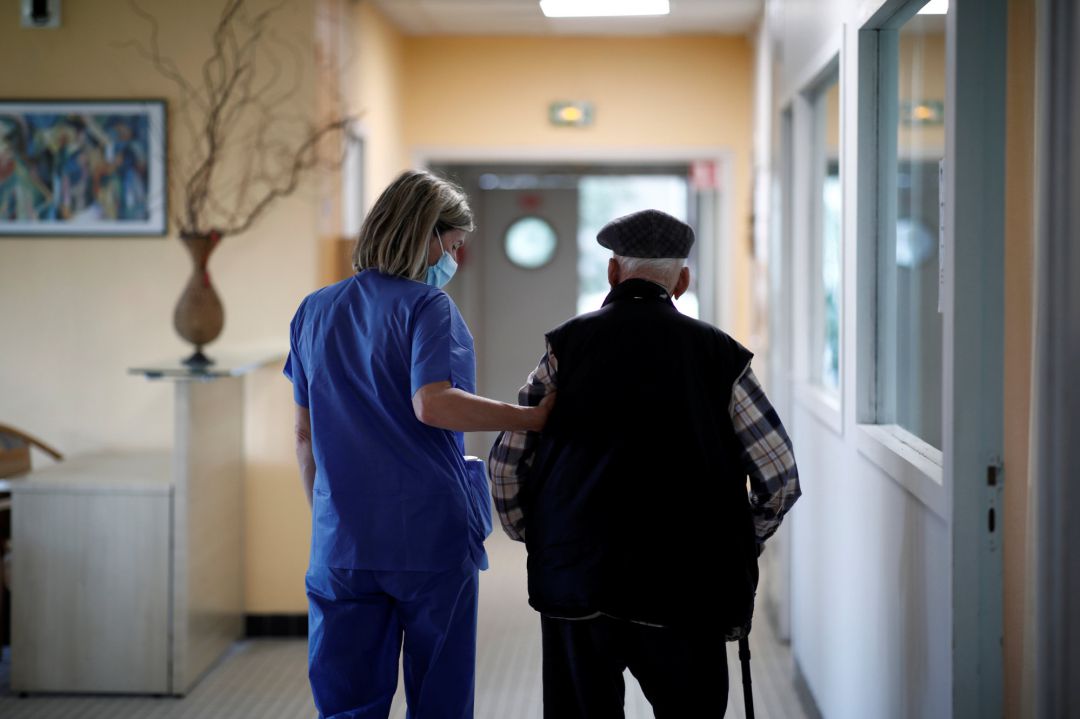 Un residente ayudado por una auxiliar de enfermería Un residente ayudado por una auxiliar de enfermería