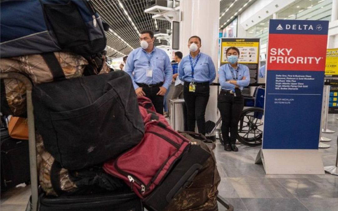 Personal de seguridad en un aeropuerto con mascarillas por el coronavirus Personal de seguridad en un aeropuerto con mascarillas por el coronavirus