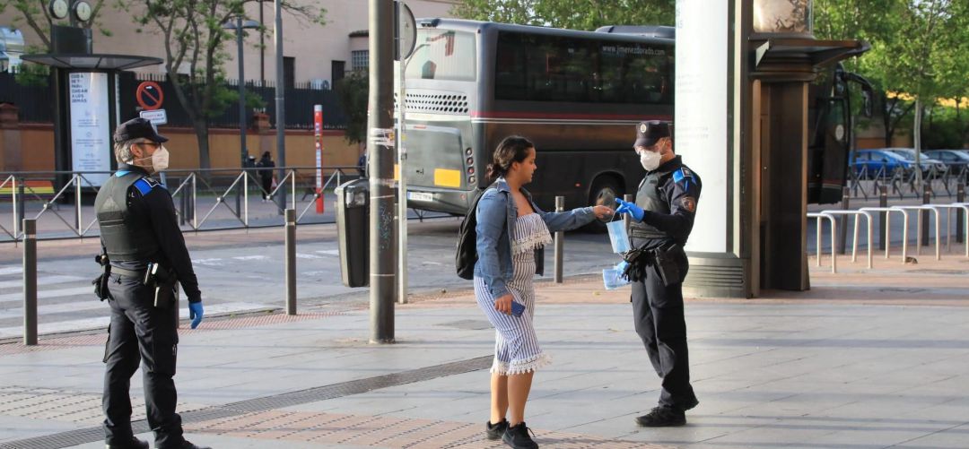 Un agente de Policía local de Getafe entrega una mascarilla a una ciudadana Un agente de Policía local de Getafe entrega una mascarilla a una ciudadana