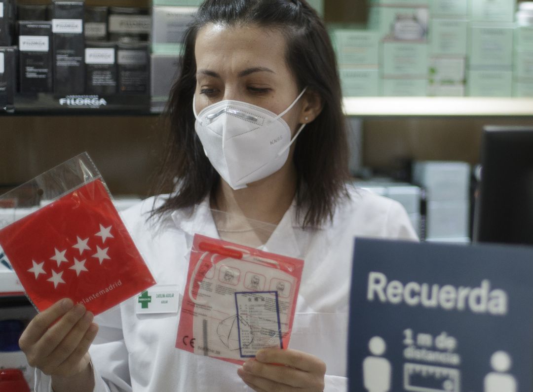 Una farmacéutica muestra una mascarilla en una farmacia madrileña. Una farmacéutica muestra una mascarilla en una farmacia madrileña.