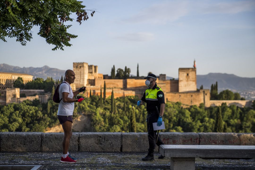 Un policía habla en Granada con un corredor Un policía habla en Granada con un corredor