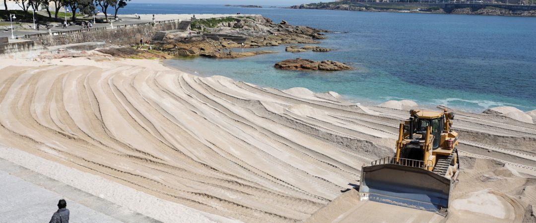 Máquina excavadora retira la duna en la playa del Riazor Máquina excavadora retira la duna en la playa del Riazor