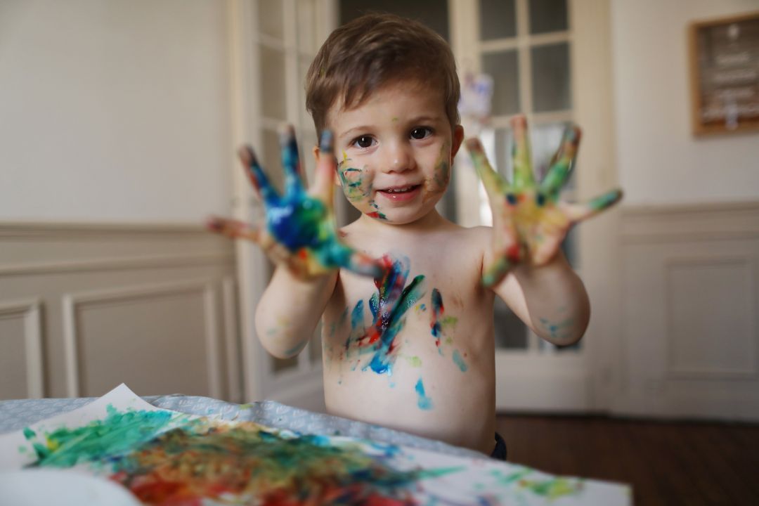 Un pequeño juega con pintura. Un pequeño juega con pintura.