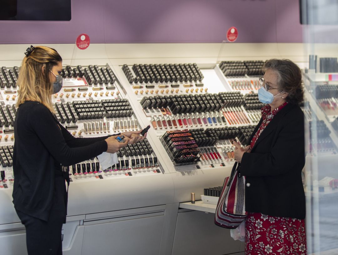 Una empleada de una tienda de cosmética atiende a una clienta Una empleada de una tienda de cosmética atiende a una clienta