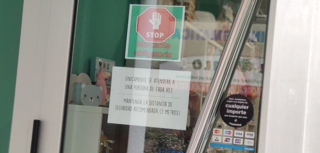 Puerta de un comercio con avisos de los protocolos frente al coronavirus Puerta de un comercio con avisos de los protocolos frente al coronavirus