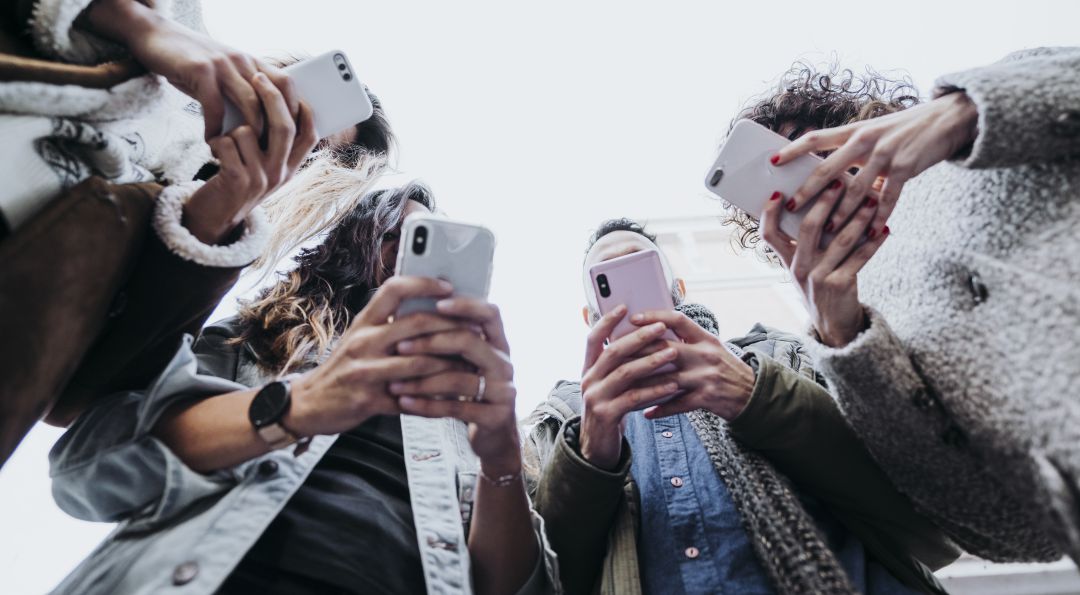 Varios jóvenes con su teléfono móvil. Varios jóvenes con su teléfono móvil.