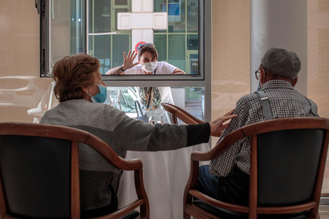 Una persona conversa con sus padres a través de una ventana habilitada en la residencia de mayores Ballesol Patacona, en Valencia, para que los residentes puedan recibir visitas de sus familiares Una persona conversa con sus padres a través de una ventana habilitada en la residencia de mayores Ballesol Patacona, en Valencia, para que los residentes puedan recibir visitas de sus familiares