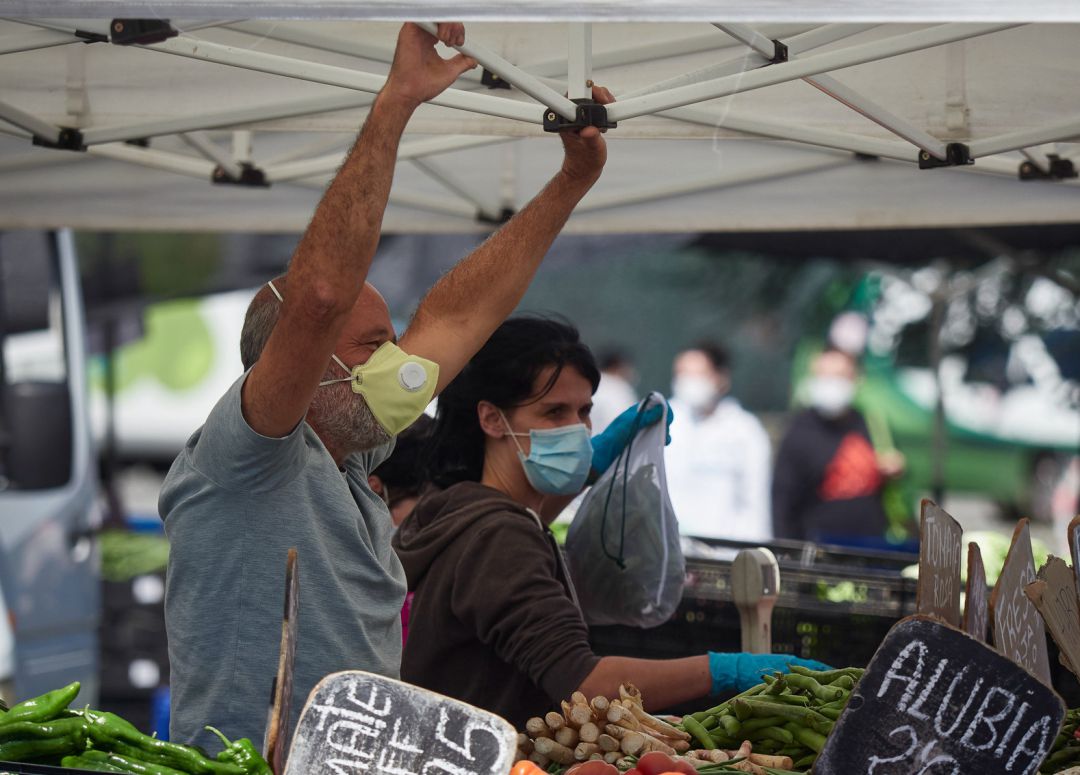 Un trabajador durante el primer dia de retorno de los puestos del mercadillo de Pamplona, donde Policia Municipal, SAR Navarra y Proteccion civil se han encargado de controlar el aforo, repartir mscarillas y ayudar a los dueños de los puestos a prepararse contra el covid19. Un trabajador durante el primer dia de retorno de los puestos del mercadillo de Pamplona, donde Policia Municipal, SAR Navarra y Proteccion civil se han encargado de controlar el aforo, repartir mscarillas y ayudar a los dueños de los puestos a prepararse contra el covid19.