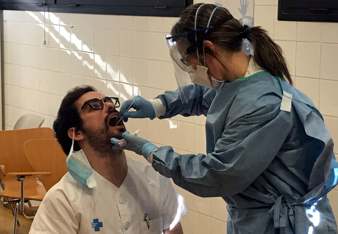 Una profesional sanitaria realiza una prueba de coronavirus a un compañero. Una profesional sanitaria realiza una prueba de coronavirus a un compañero.