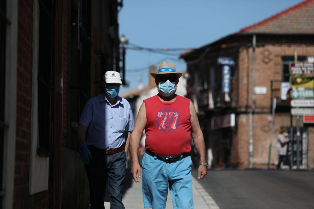 Dos hombres protegidos con mascarilla andan por una calle del pueblo madrileño de Algete. Dos hombres protegidos con mascarilla andan por una calle del pueblo madrileño de Algete.