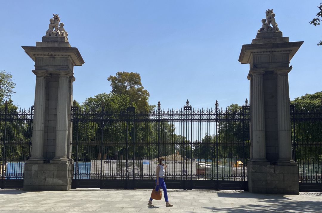 Una mujer pasa al lado de una de las puertas del parque de El Retiro. Una mujer pasa al lado de una de las puertas del parque de El Retiro.