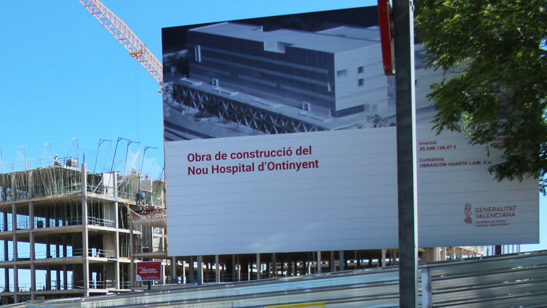 Foto de les obres de l'hospital amb el cartell davant Foto de les obres de l'hospital amb el cartell davant