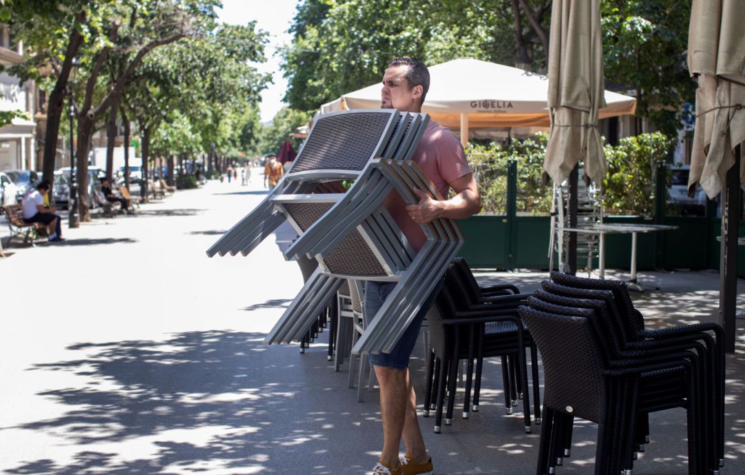 Un treballador d'un restaurant de la Rambla Catalunya prepara la terrassa de l'establiment Un treballador d'un restaurant de la Rambla Catalunya prepara la terrassa de l'establiment