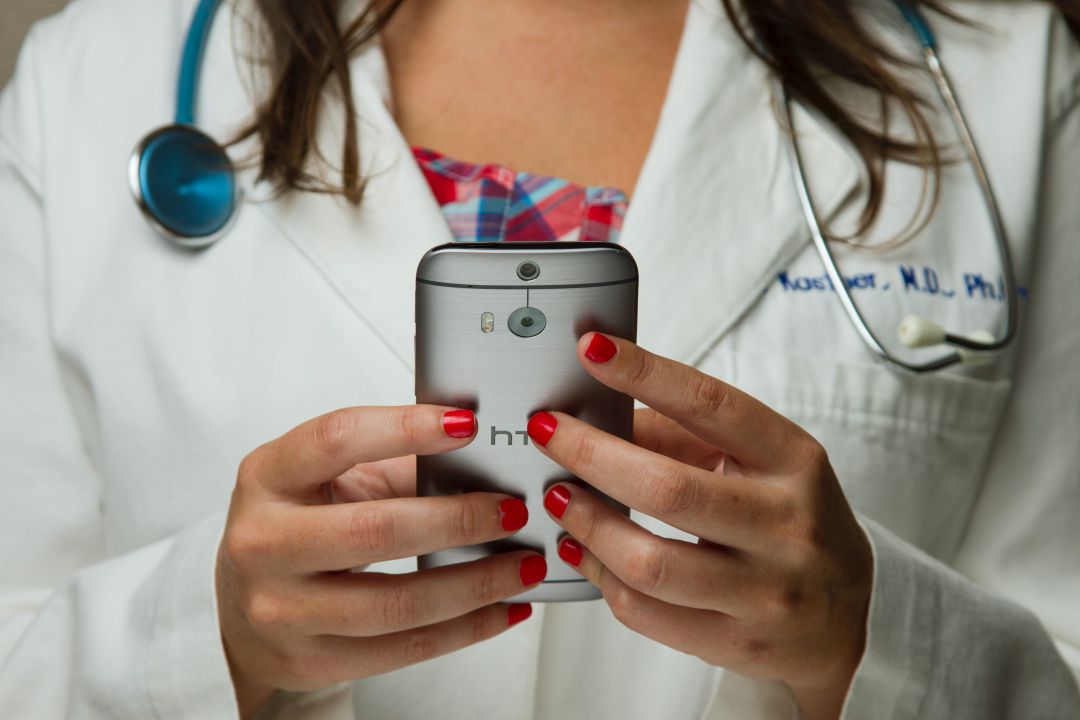 Doctora sostiene un smartphone Doctora sostiene un smartphone