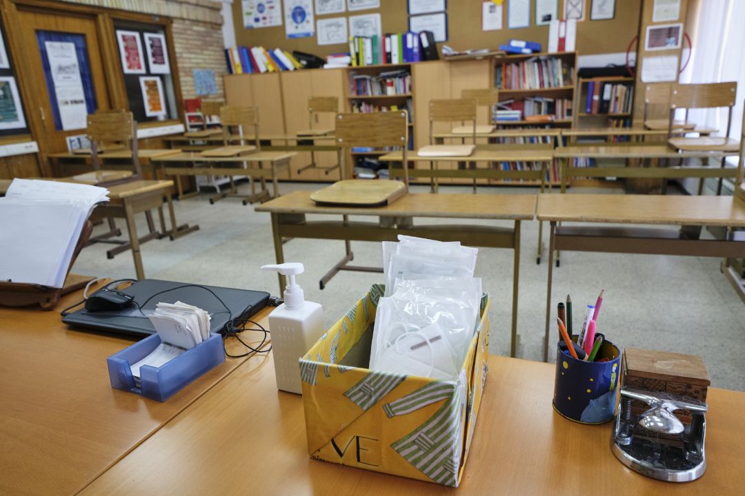 Mascarillas y gel desinfectante en la mesa del profesor de un aula de un colegio Mascarillas y gel desinfectante en la mesa del profesor de un aula de un colegio