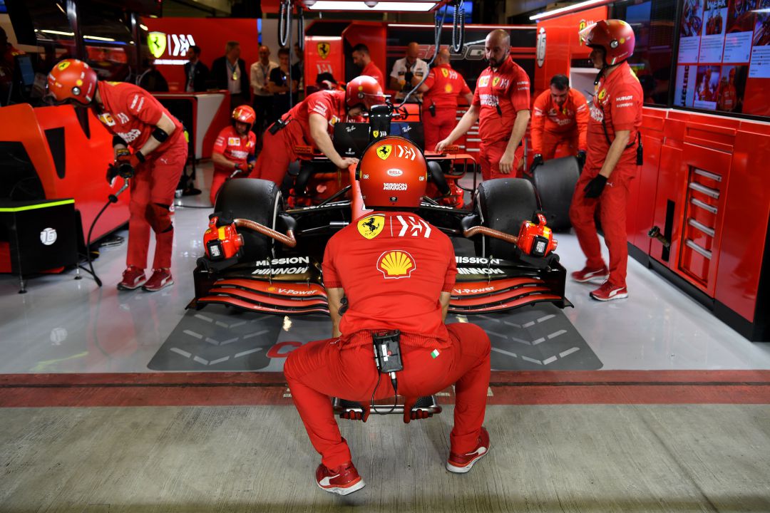 Mecánicos de la Fórmula 1 con un coche de Ferrari Mecánicos de la Fórmula 1 con un coche de Ferrari