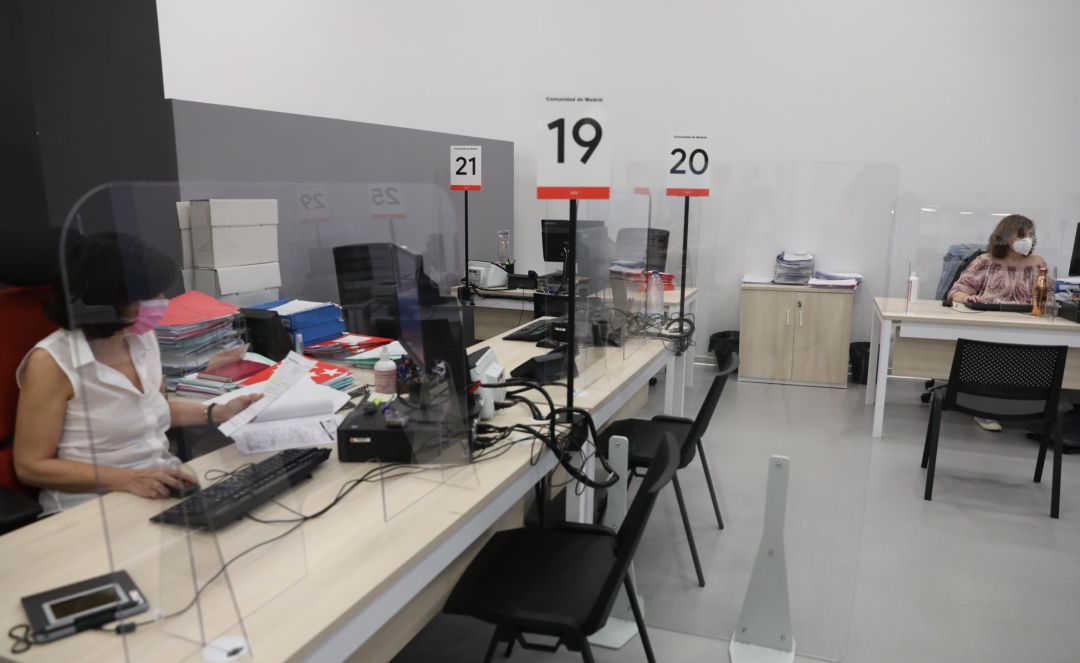 Dos trabajadoras de la Oficina del Empleador protegida con mascarilla y con una pantalla separadora en su mesa. Dos trabajadoras de la Oficina del Empleador protegida con mascarilla y con una pantalla separadora en su mesa.