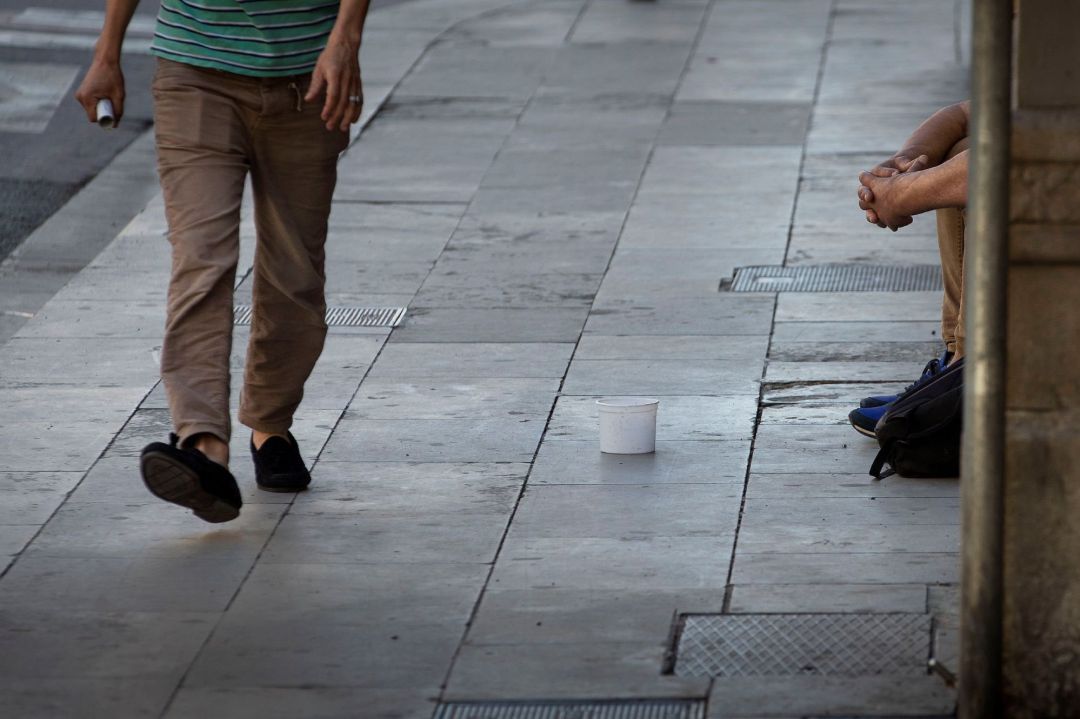 Un hombre pide limosna en la calle. Un hombre pide limosna en la calle.