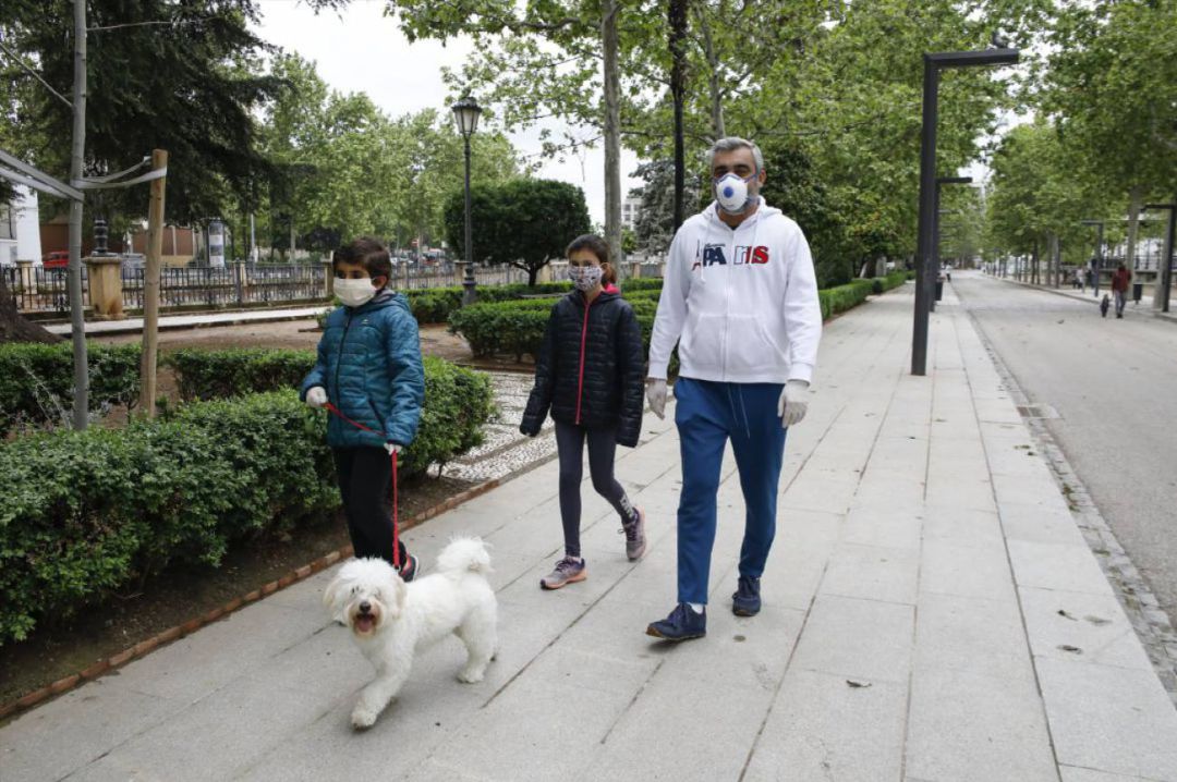 Familia paseando con mascarillas para evitar contagios de Covid-19 Familia paseando con mascarillas para evitar contagios de Covid-19