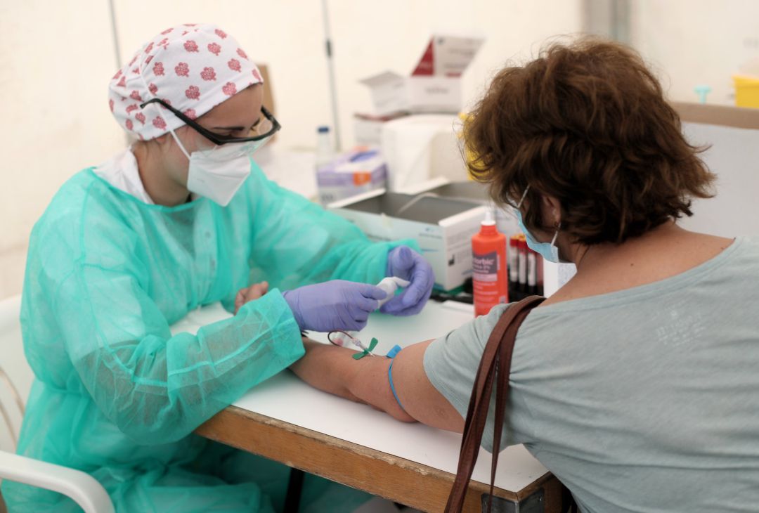 Un sanitario realiza una prueba diagnóstica de coronavirus a un paciente Un sanitario realiza una prueba diagnóstica de coronavirus a un paciente