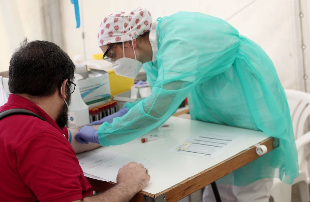 Un sanitario junto a un paciente durante una jornada del test serológico masivo de coronavirus de Torrejón Un sanitario junto a un paciente durante una jornada del test serológico masivo de coronavirus de Torrejón