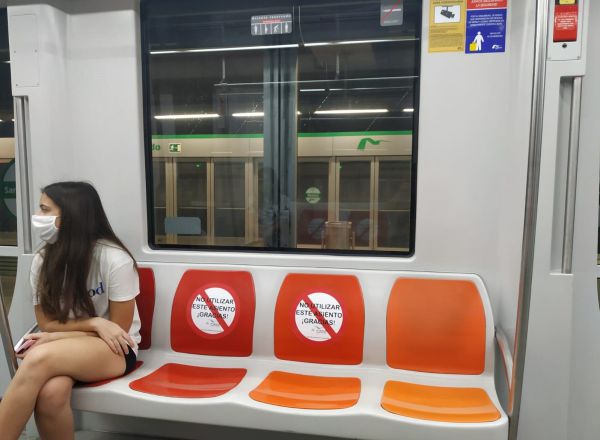 Una joven con mascarilla viaja en el Metro de Sevilla