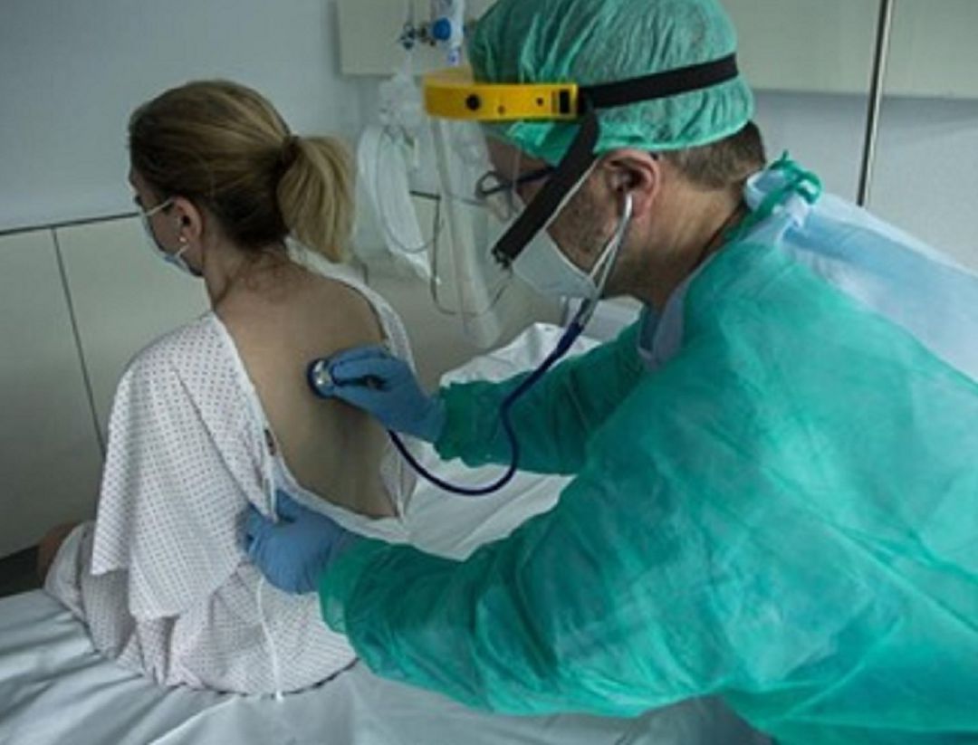 Sanitario atendiendo a una paciente Sanitario atendiendo a una paciente