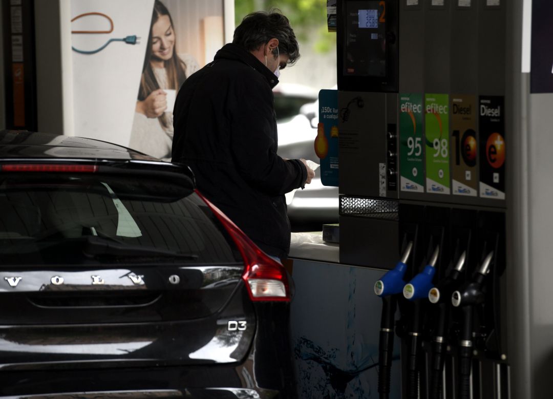 Un hombre echa gasolina a su coche en una gasolinera Un hombre echa gasolina a su coche en una gasolinera
