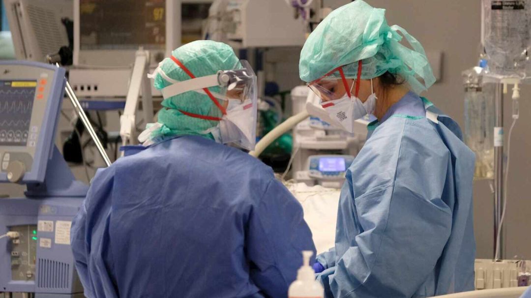 Dos sanitarios en una UCI. Dos sanitarios en una UCI.