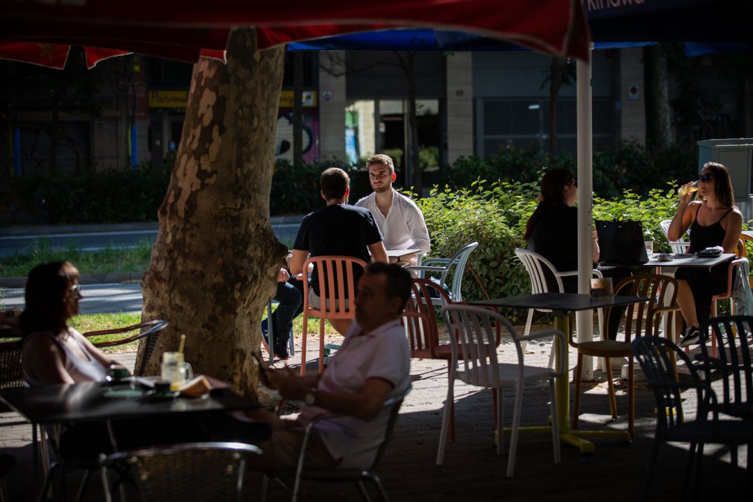 Varias personas disfrutan en la terraza de un bar Varias personas disfrutan en la terraza de un bar