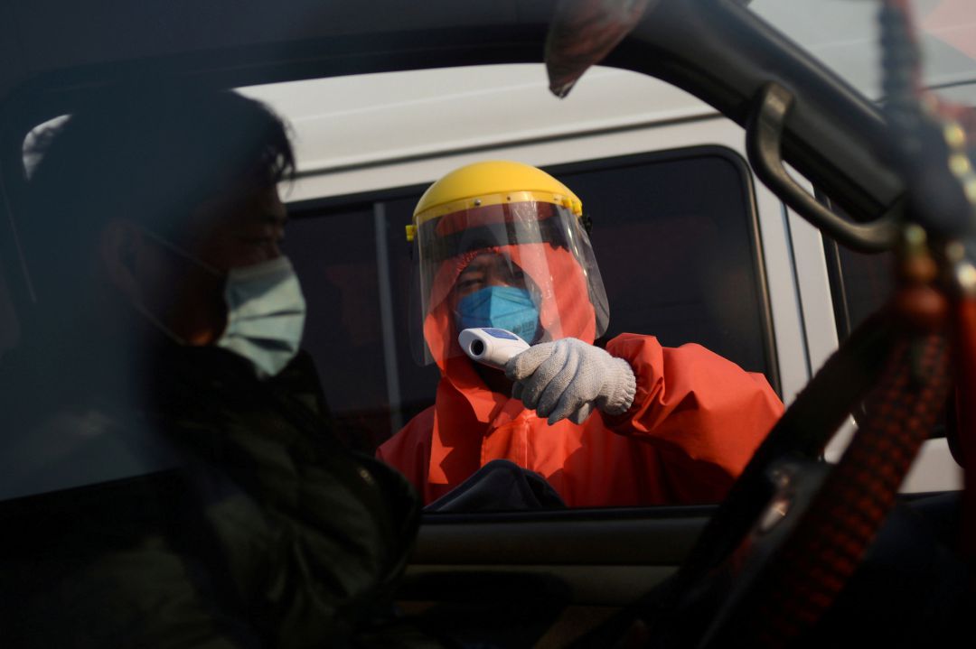 Un trabajador compreba la temperatura de un hombre desde el interior de su vehículo en las instalaciones del mercado de Xinfadi, en Pekín (China). Un trabajador compreba la temperatura de un hombre desde el interior de su vehículo en las instalaciones del mercado de Xinfadi, en Pekín (China).