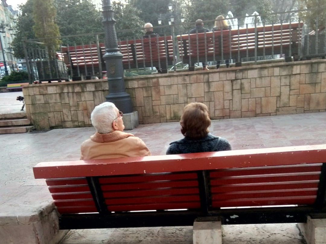 Ancianos descansando en un banco de la Plaza de La Escandalera de Oviedo Ancianos descansando en un banco de la Plaza de La Escandalera de Oviedo