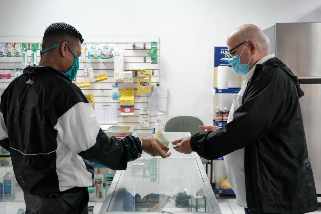 Un cliente paga sus medicamentos en una farmacia Un cliente paga sus medicamentos en una farmacia