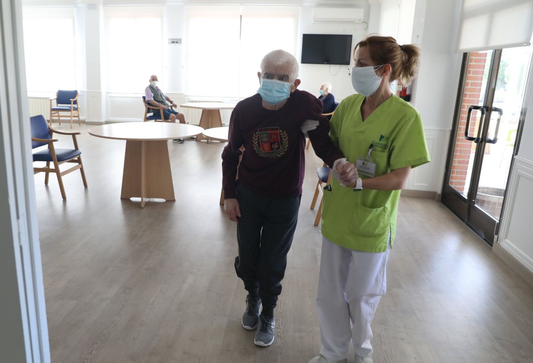 Una gerocultura ayuda a caminar a un residente Una gerocultura ayuda a caminar a un residente
