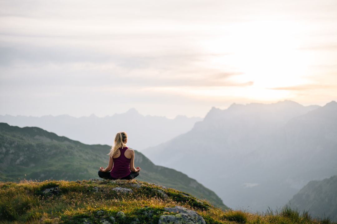 Mujer haciendo yoga en la montaña Mujer haciendo yoga en la montaña