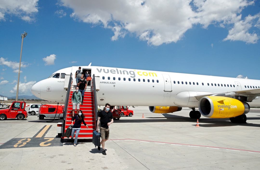 Passengers leave a Vueling plane upon their arrival at Palma de Mallorca airport on the Balearic Islands, Spain, June 13, 2020. Passengers leave a Vueling plane upon their arrival at Palma de Mallorca airport on the Balearic Islands, Spain, June 13, 2020.