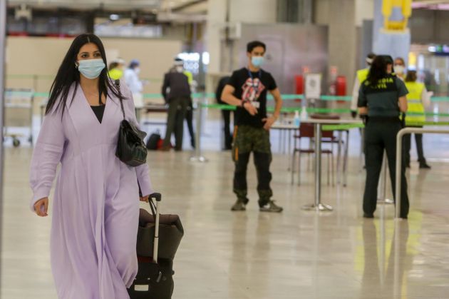 Agentes de la Guardia Civil y personal del Aeropuerto de Madrid-Barajas Adolfo Suárez controlan la llegada de pasajeros el día en el que se estrena el triple control sanitario de seguridad. Agentes de la Guardia Civil y personal del Aeropuerto de Madrid-Barajas Adolfo Suárez controlan la llegada de pasajeros el día en el que se estrena el triple control sanitario de seguridad.