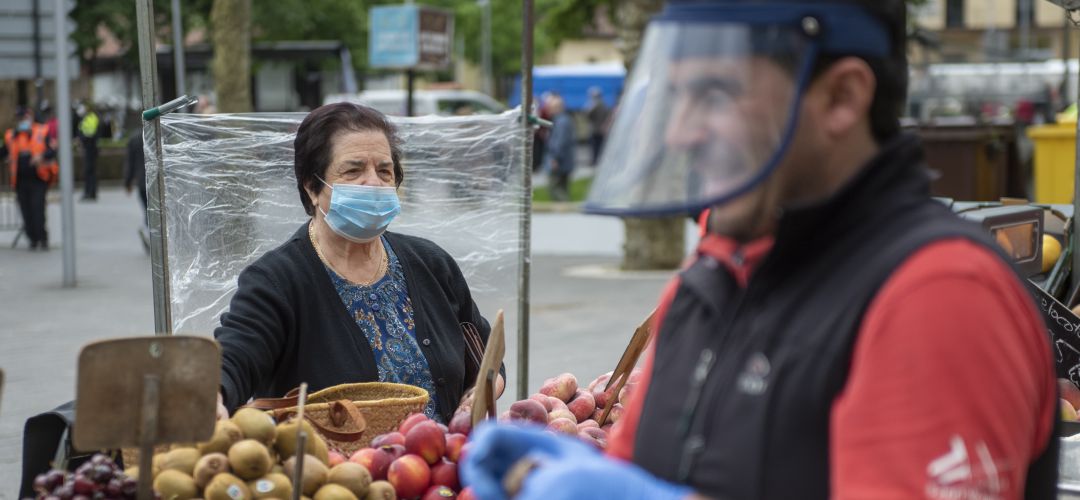 Una anciana realiza la compra en un mercadillo. Una anciana realiza la compra en un mercadillo.