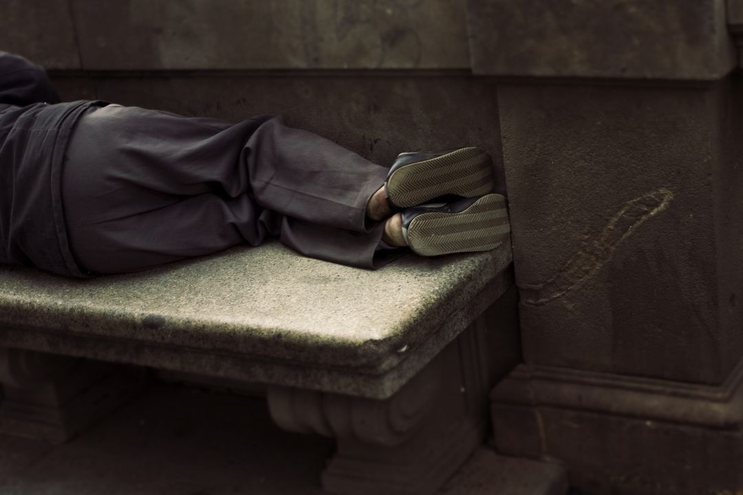 Un hombre durmiendo sobre un banco. Un hombre durmiendo sobre un banco.