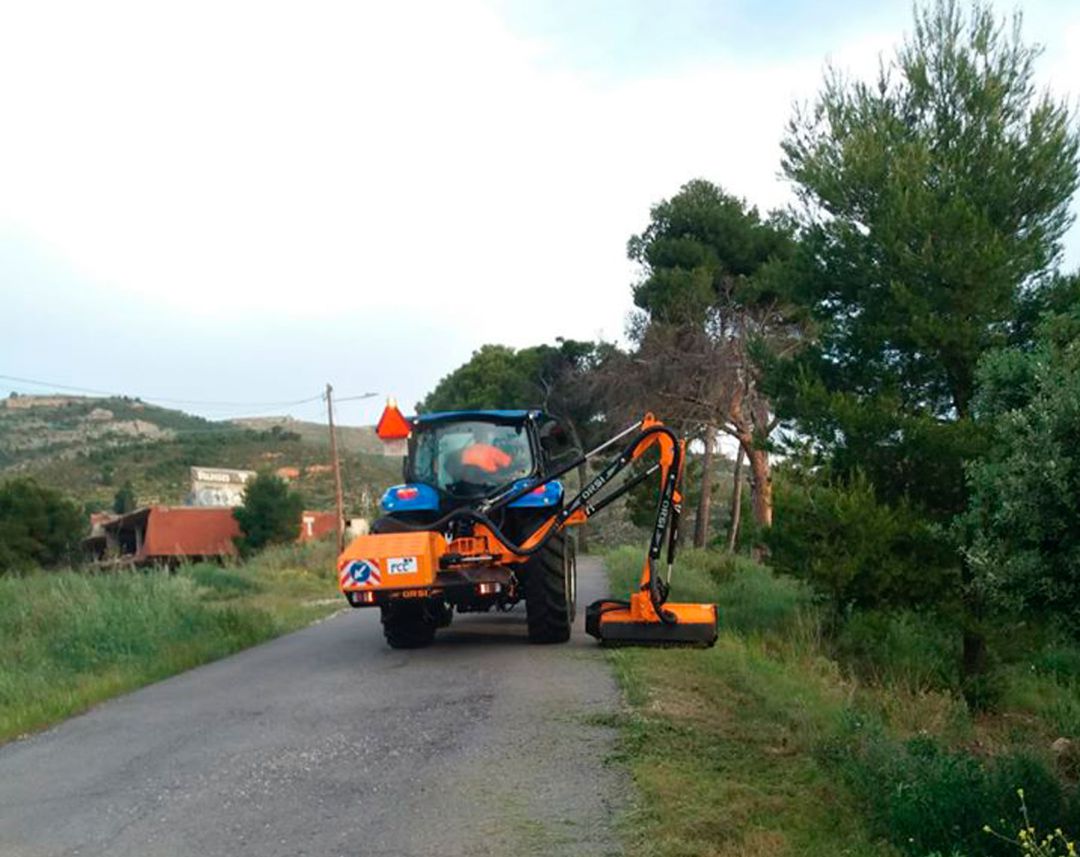 Una máquina cortando hierba en la orilla de un camino. Una máquina cortando hierba en la orilla de un camino.