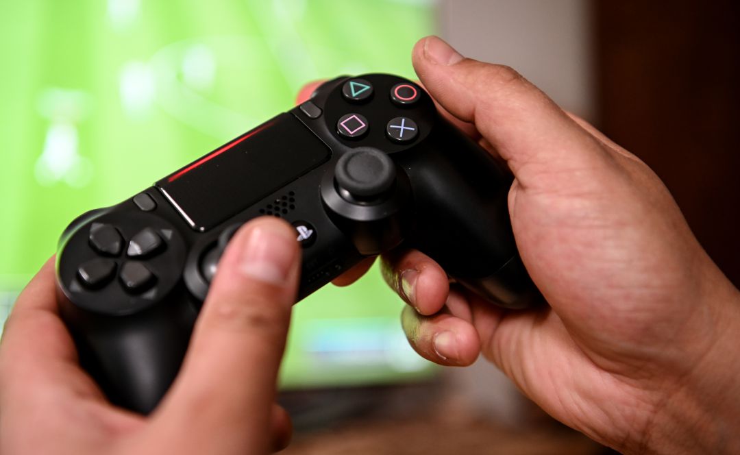 Una persona jugando a la PlayStation 4. Una persona jugando a la PlayStation 4.