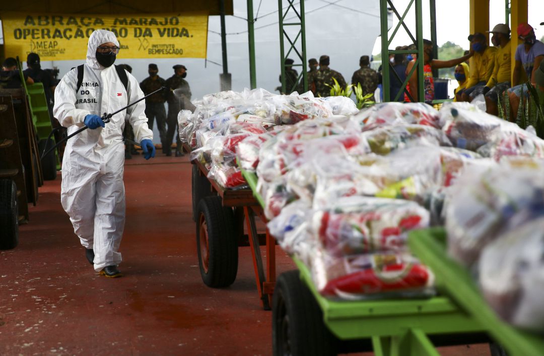 Un soldado brasileño desinfecta las bolsas de ayuda humanitaria que llegaron al municipio paraense de Afua, en el norte de Brasil, para paliar los estragos de la pandemia de la COVID-19. Un soldado brasileño desinfecta las bolsas de ayuda humanitaria que llegaron al municipio paraense de Afua, en el norte de Brasil, para paliar los estragos de la pandemia de la COVID-19.