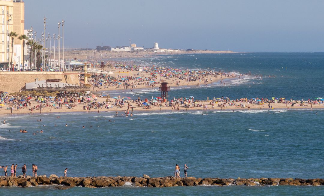 CÁDIZ, SPAIN - JUNE 27: Many people crowd together on the beach to enjoy the hot weather on the beach of Santa María del Mar CÁDIZ, SPAIN - JUNE 27: Many people crowd together on the beach to enjoy the hot weather on the beach of Santa María del Mar