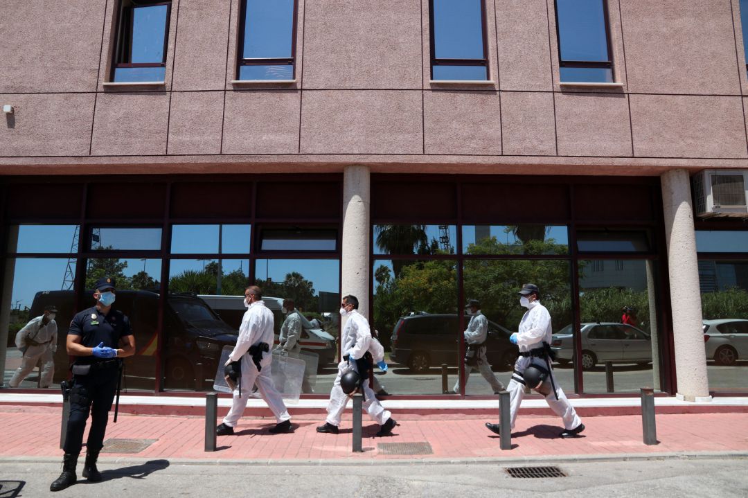 Agentes de la Policía Nacional equipados con Equipos de Protección Individual custodian el centro de acogida de Cruz Roja en Málaga Agentes de la Policía Nacional equipados con Equipos de Protección Individual custodian el centro de acogida de Cruz Roja en Málaga