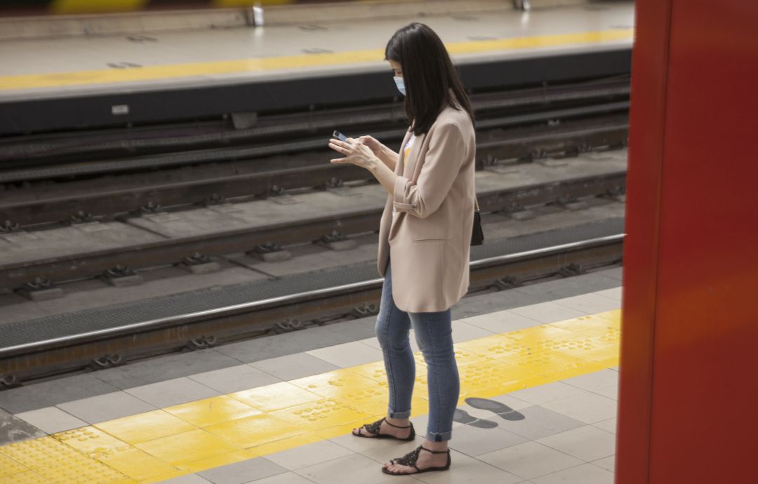 Una mujer utiliza el móvil en el metro. Una mujer utiliza el móvil en el metro.