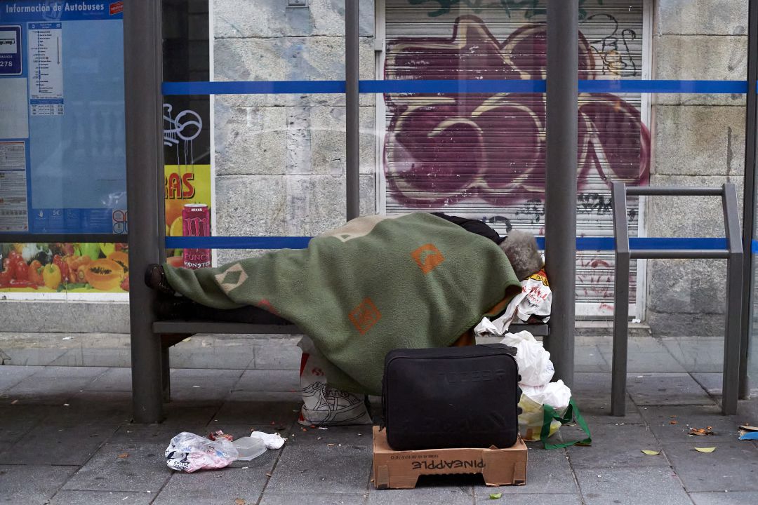 Una persona duerme en una marquesina de autobús en Madrid Una persona duerme en una marquesina de autobús en Madrid