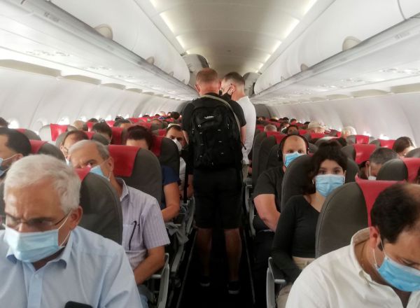 Varios pasajeros se acomodan en sus asientos sin distancia de seguridad antes del despegue de un vuelo en el aeropuerto Adolfo Suárez-Barajas en Madrid.