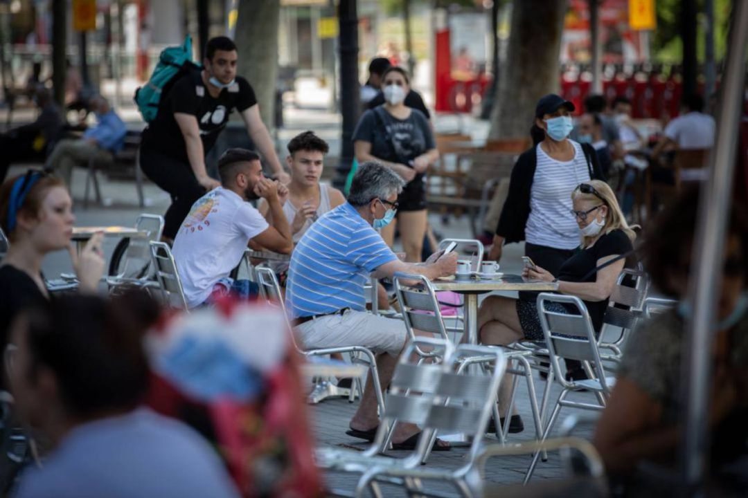 Varias personas disfrutan en la terraza de un bar Varias personas disfrutan en la terraza de un bar
