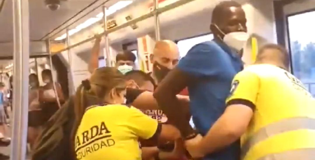 Fotograma del vídeo compartido en redes donde se ve a los guardias de seguridad y a ciudadanos retener y esposar al joven negro por no llevar correctamente la mascarilla en el metro de València Fotograma del vídeo compartido en redes donde se ve a los guardias de seguridad y a ciudadanos retener y esposar al joven negro por no llevar correctamente la mascarilla en el metro de València