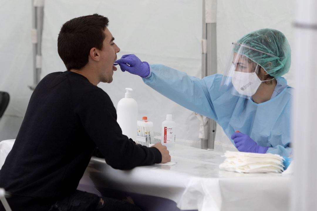 Una sanitaria le realiza un frotis bucal a un vecino Una sanitaria le realiza un frotis bucal a un vecino